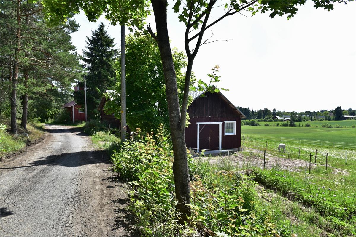 Juskunmäenkadun varrella näkyy hevostalli (sisältää vanhan riihen) ja kuivaamo. Pellon takana erottuu kirkon katonharjalta nouseva kellotornina toimiva kattoratsastaja.&nbsp;(Teija Ahola&nbsp;2023)