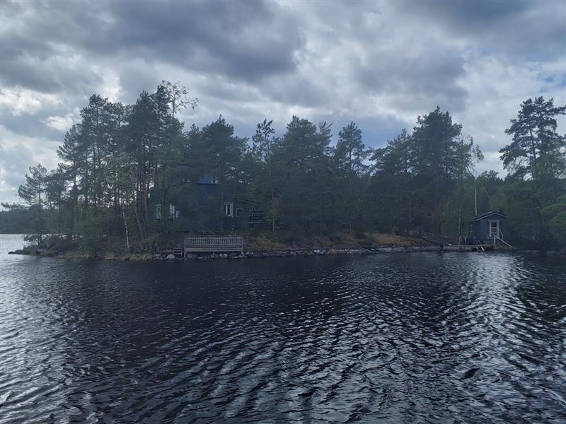 Näkymä pienen saaren kärjessä sijaitsevaa huvilaa ja sen rantasaunan kupeessa sijaitsevaa saunaa kohden.&nbsp;(Dan Ronimus&nbsp;5/2022)