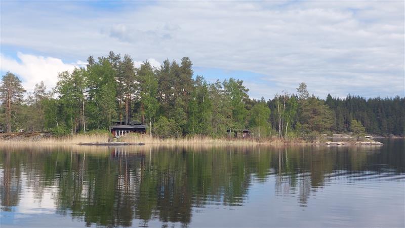 Saunarakennus ja rannassa sijaitseva talousrakennus saaren länsipuolelta kuvattuna.&nbsp;(Dan Ronimus&nbsp;5/2022)