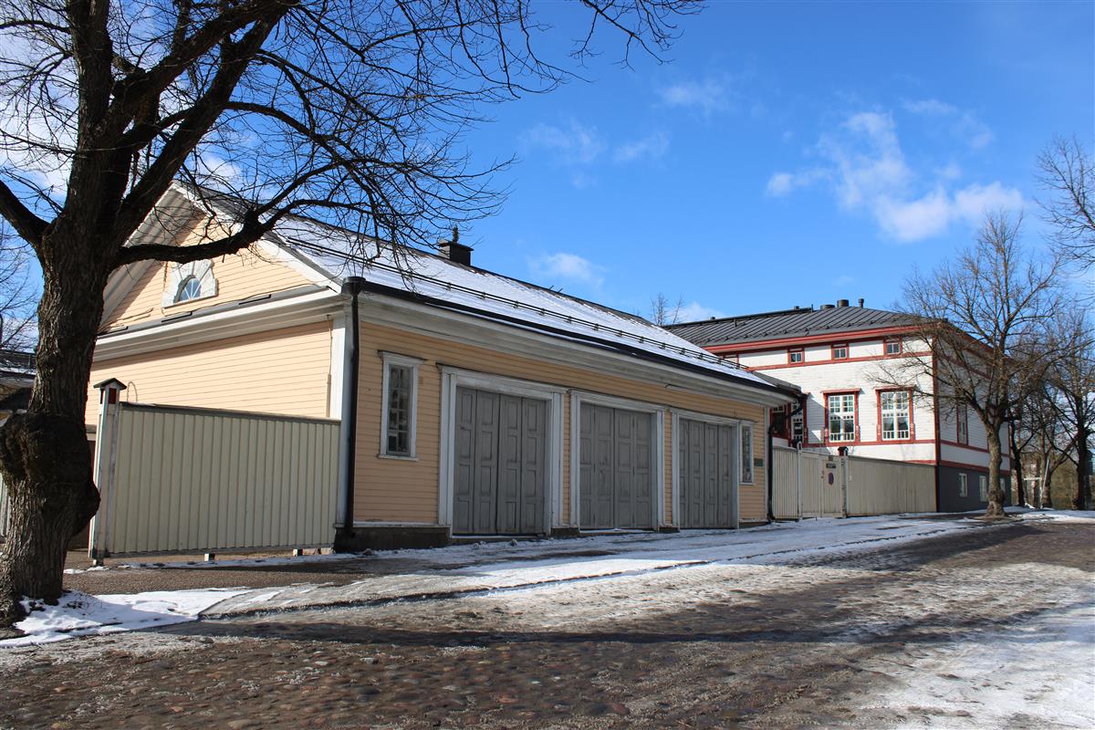 Rakennukset 1 (oikealla) ja 4 (vasemmalla), eli entinen Seurahuoneen ja poliisilaitoksen talo ja entinen palokunnan vaunuvaja.&nbsp;(Liina Luoma&nbsp;19.3.2025)