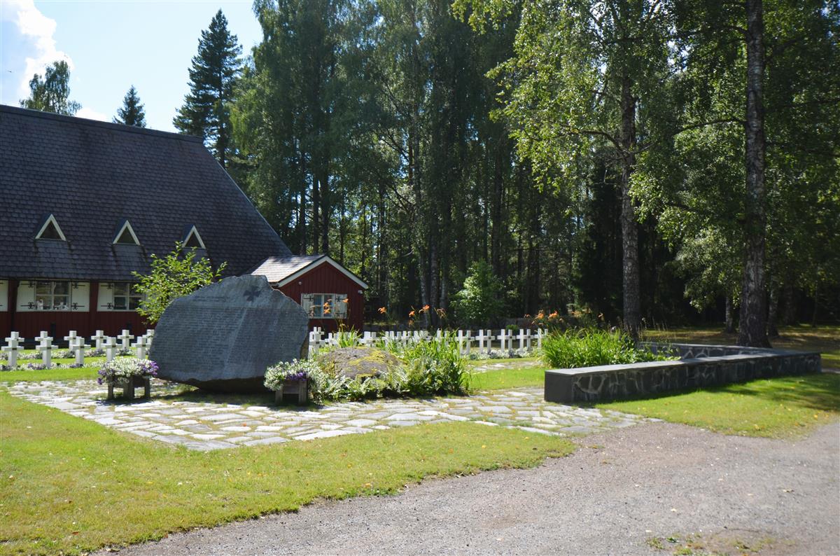 Näkymä Nuijamaan hautausmaalta lounaaseen päin, kohti Jaettu pitäjä -sankarimuistomerkkiä. Taustalla Nuijamaan kirkko.&nbsp;(Päivi Makkonen&nbsp;2026)