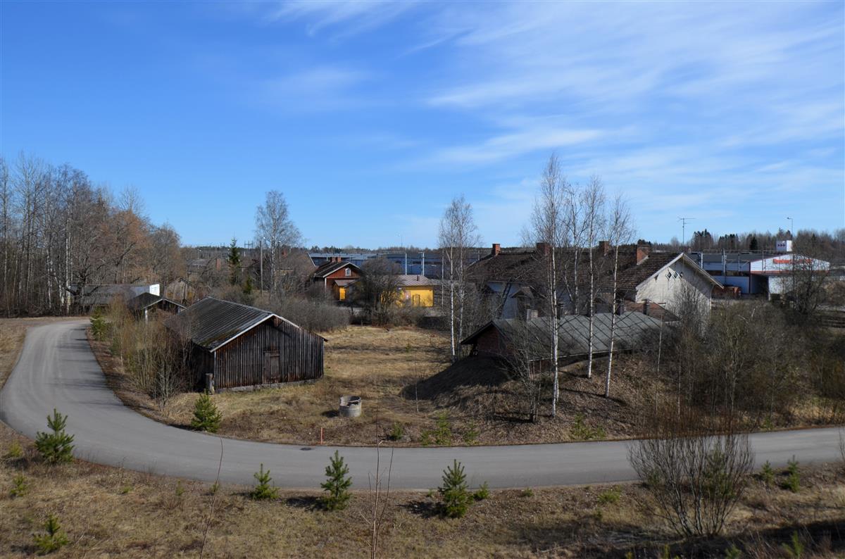 Näkymä Suoanttilantien sillalta aseman alueelle, kohti kaakkoa. Etualalla rautatieläisten asuinrakennuksen pihapiiri, keskellä punainen asuinrakennus.&nbsp;(Päivi Makkonen&nbsp;2026)
