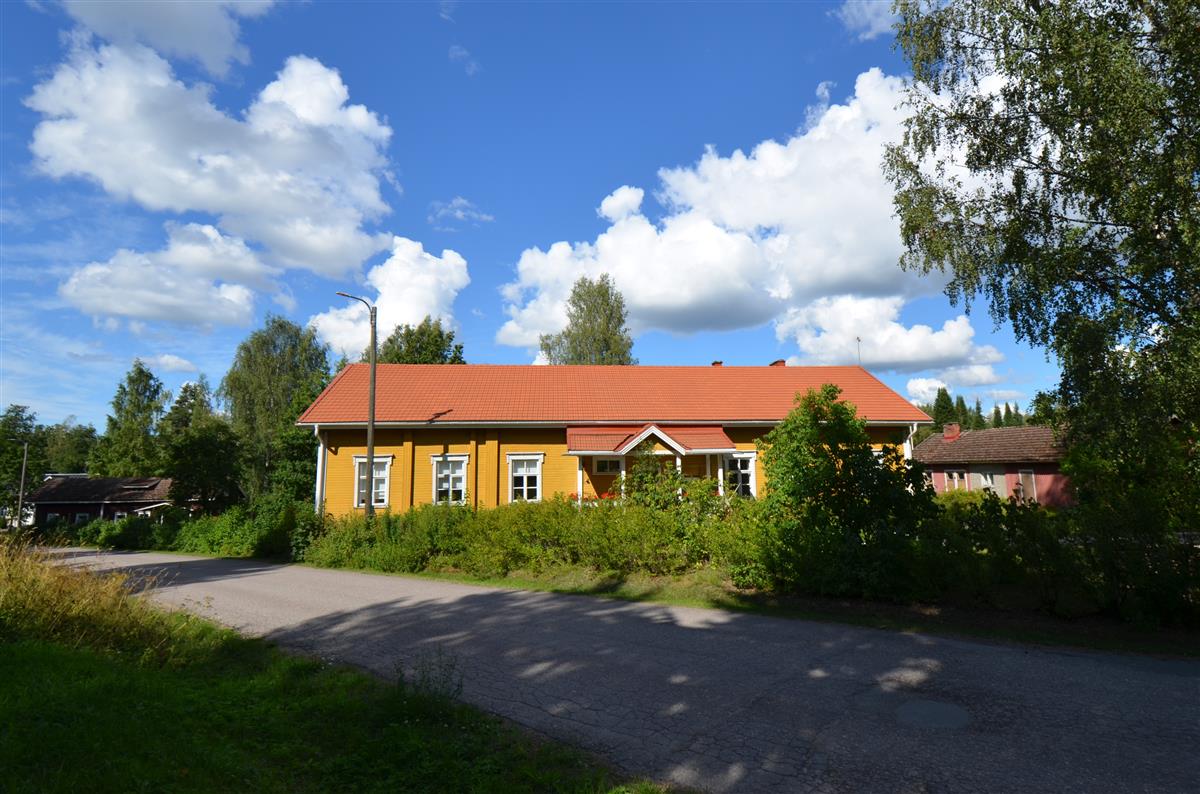Näkymä yli Oravaniementien kohti Hauta-Ollin mökkiä, Parikkalan pitäjäntupaa ja sen piharakennusta.&nbsp;(Päivi Makkonen&nbsp;2025)