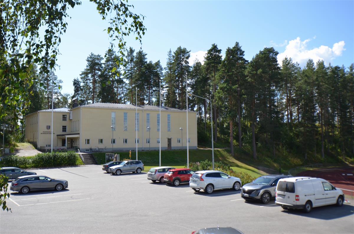 Parikkalan kunnantalo pohjoisesta päin kuvattuna. Taustalla Sikoharju, oikealla urheilukenttä.&nbsp;(Päivi Makkonen&nbsp;2025)