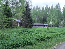 Kuva: Pihapiirin kaksi aittaa ja niiden viereen sijoittuva asuinrakennus.&nbsp;(Dan Ronimus&nbsp;5/2022)